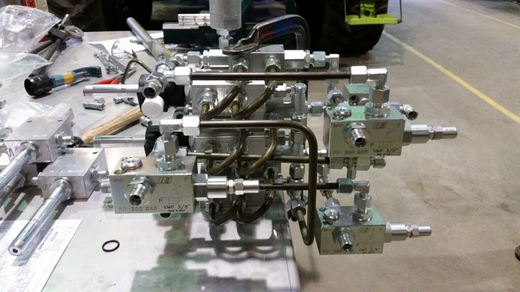 Nærbillede af et komplekst hydraulisk manifold system med præcisionsbukkede stålrør og ventiler under montage.