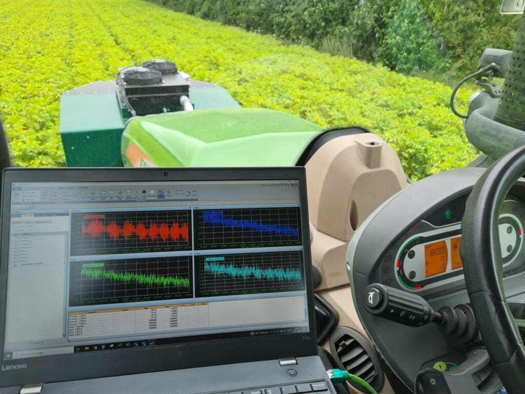 Laptop med realtidsdata og grafer til fieldtest af landbrugsmaskine i marken