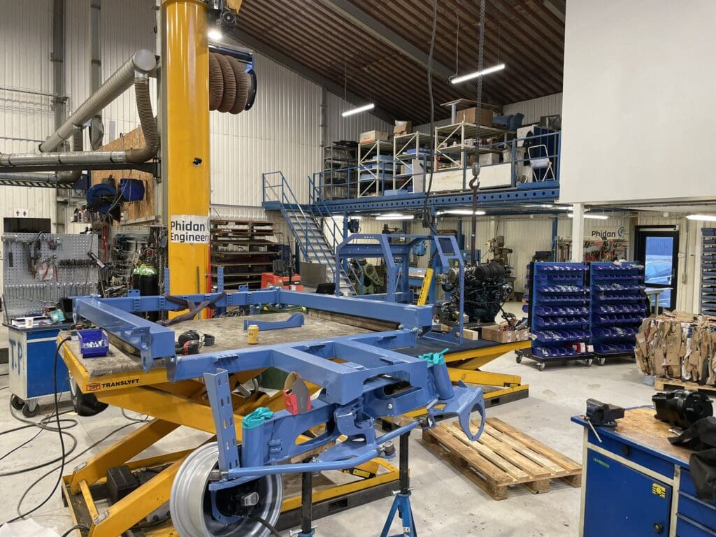Blå maskinramme under montage på gult løftebord i Phidan Engineerings værksted i Skanderborg