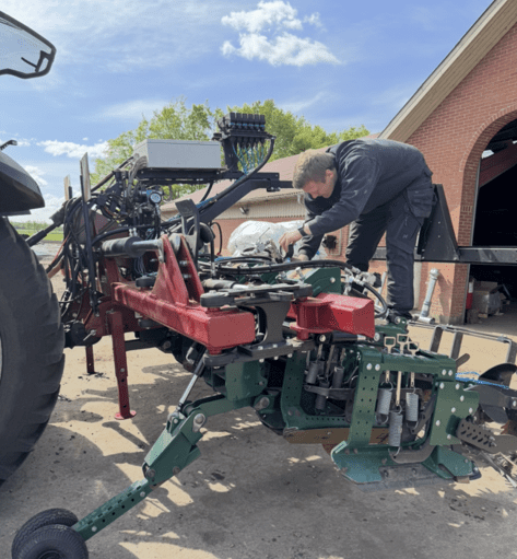 En tekniker fra Phidan Engineering udfører service og teknisk fejlfinding på en avanceret landbrugsmaskine med fokus på hydraulik og automation.