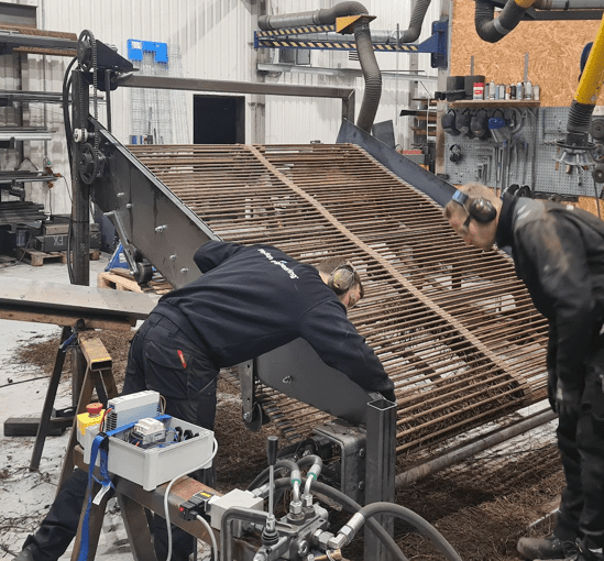 To teknikere fra Phidan Engineering udfører service, reparation og montage på en prototype af en maskinkonstruktion i et værksted.