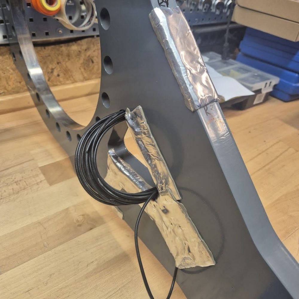 Detaljeret visning af strain gauges monteret på en metalkonstruktion til spændingsmåling og test hos Phidan Engineering.